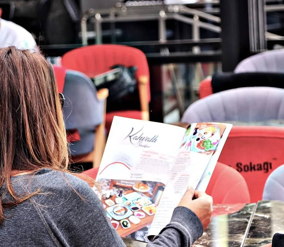 Kahve Sokağı şubesinde menüyü inceleyen misafir