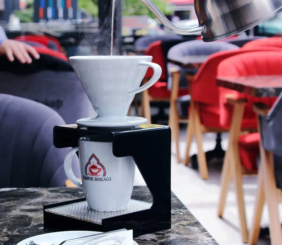 Filtre kahve demlenirken V60 hunisine sıcak suyun dökülmesi